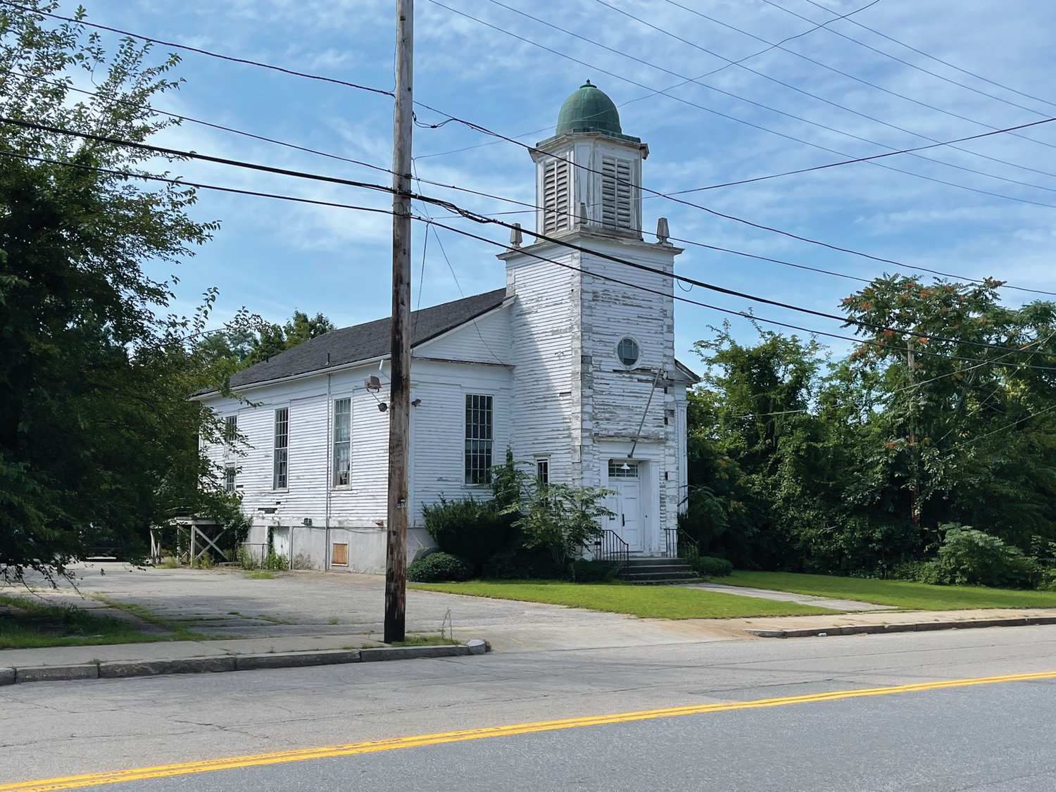 ONCE A MEETING PLACE: This historic meeting house – which began as the church for the Sprague mill village, became St. Bartholomew’s Episcopal Church, and now sits vacant – would become the home of a leasing office and commercial space under redevelopment plans for the Cranston Print Works site.